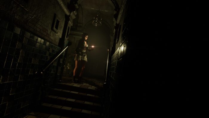 Tormented Souls protagonist Caroline Walker standing at the top of some stairs, holding a lighter.