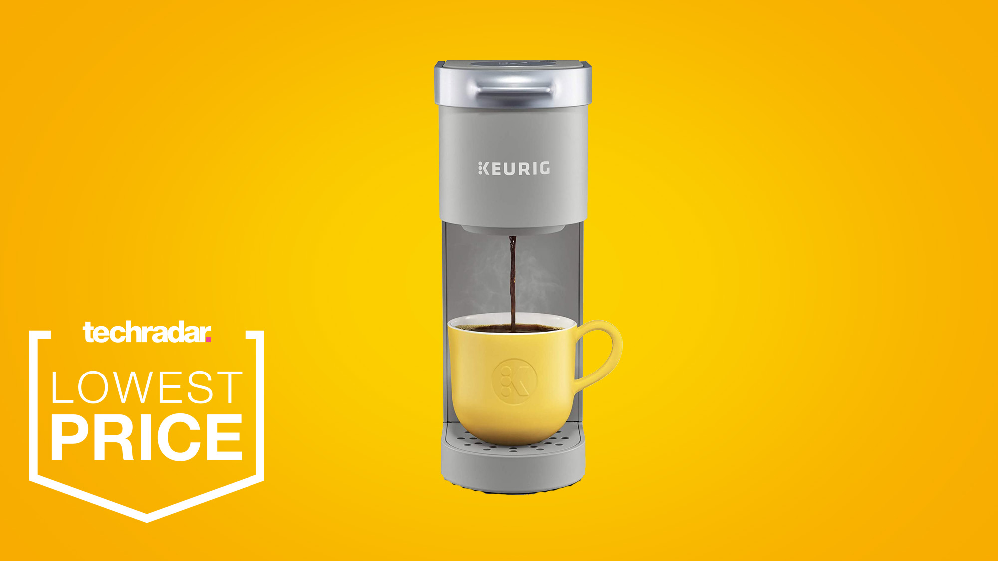 The Keurig K-Mini Coffee Maker in grey brewing coffee into a yellow mug on the cup stand on a yellow background
