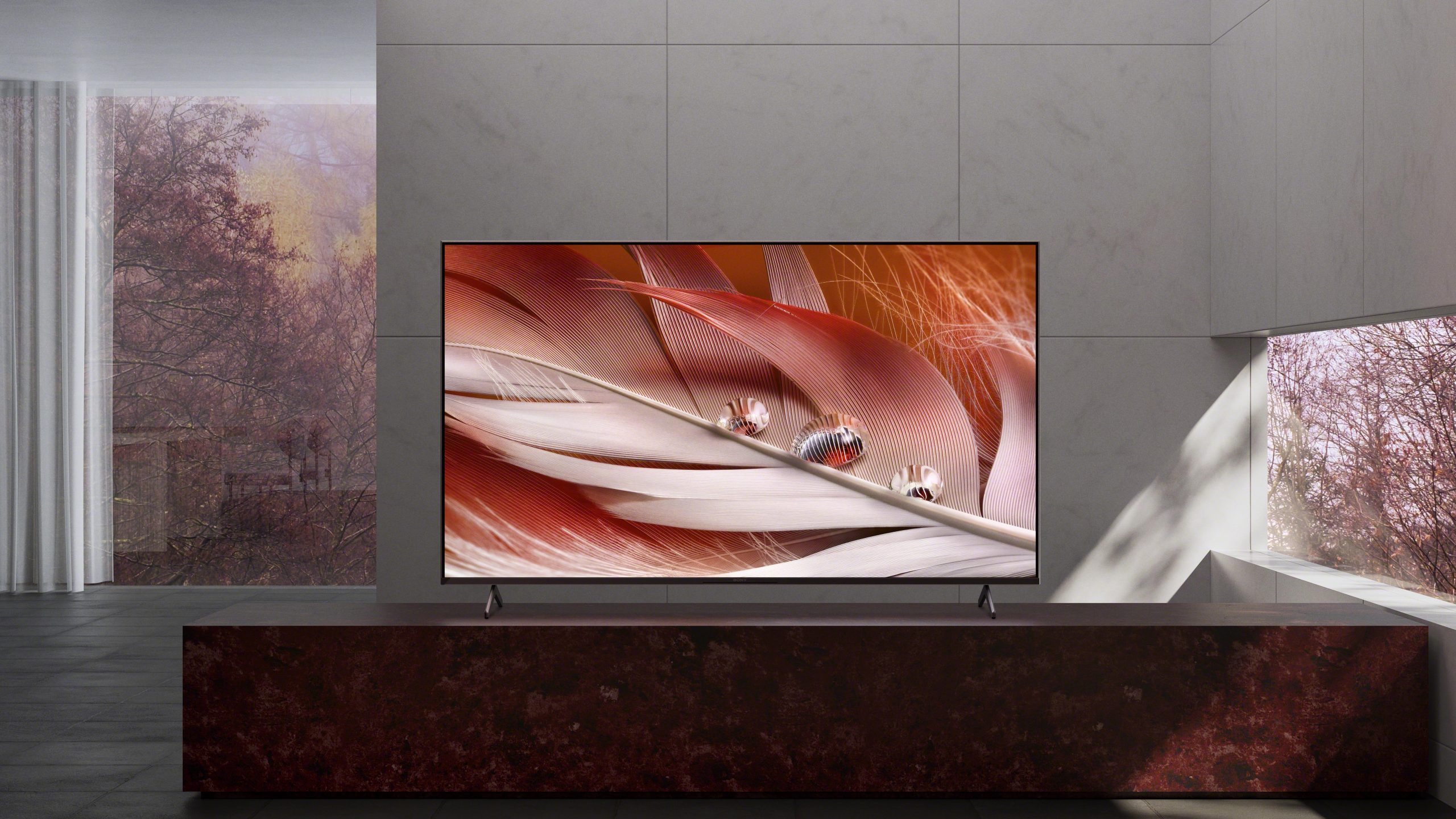 Televisor Sony X90J 4K nun soporte de televisión nunha sala de estar minimalista
