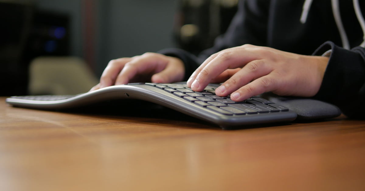 Person typing on Logitech ergonomic keyboard