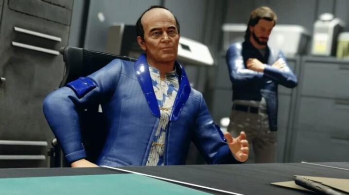 स्टारफील्ड-नीले-सूट में आदमी-डेस्क पर अपने पीछे एक आदमी के साथ ग्रे-ऑफिस-कमरे में बैठता है-768x432-718x-3669587